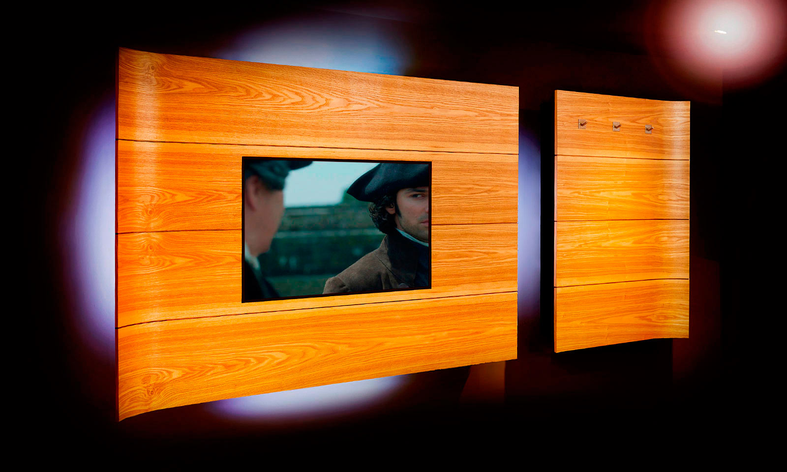 A bespoke, handmade, wall mounted home media centre, complete with hidden black shelving and LED lighting. Manufactured from curved Ash veneer, designed and installed by Mounts Hill Woodcraft.