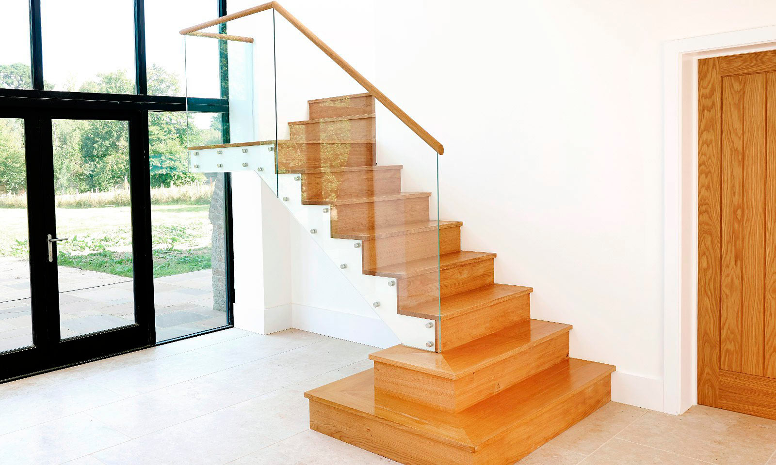 Modern Staircase. A contemporary oak staircase with a toughened glass bannister, manufactured from European oak and installed in this converted residential barn. Bespoke custom made joinery by Mounts Hill Woodcraft.